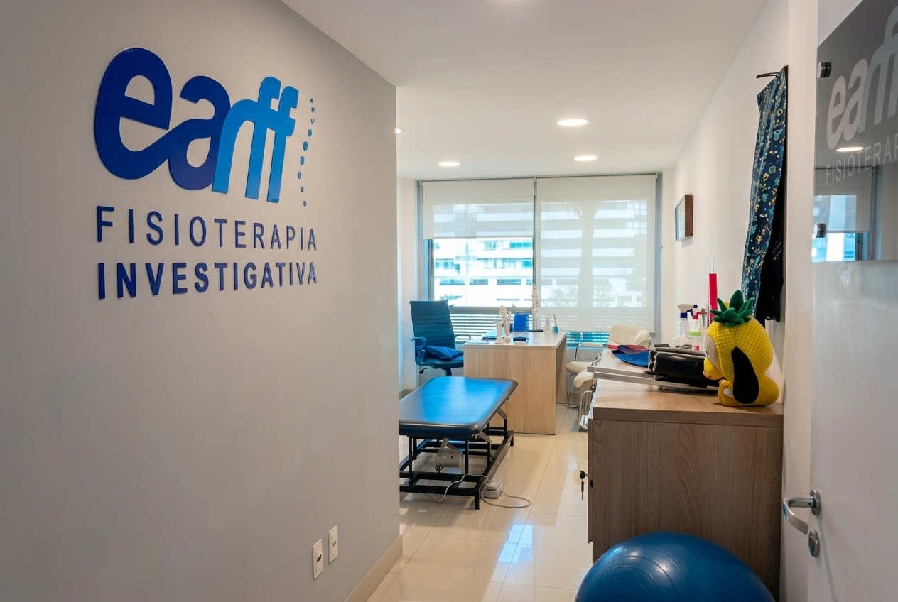 Corredor de recepção da unidade EARFF Freguesia com parede de logo EARFF Fisioterapia Investigativa em azul, maca de tratamento azul-marinho, móvel de madeira com organizadores e boneco de pelúcia amarelo, janela com persiana translúcida ao fundo, piso de porcelanato claro, ambiente clínico moderno e clean, fotografia realista